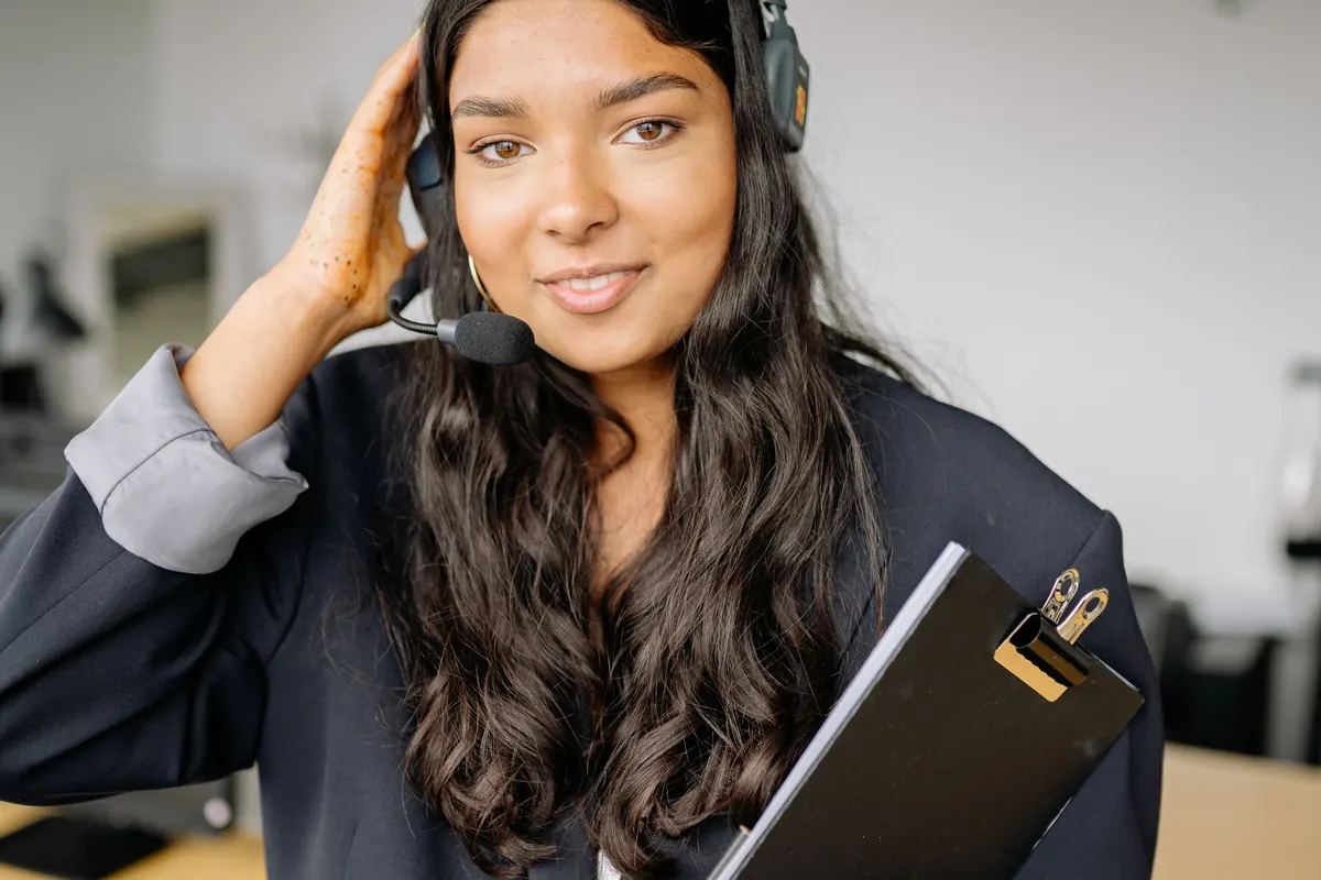 Customer service agent wearing a headset holding a clipboard