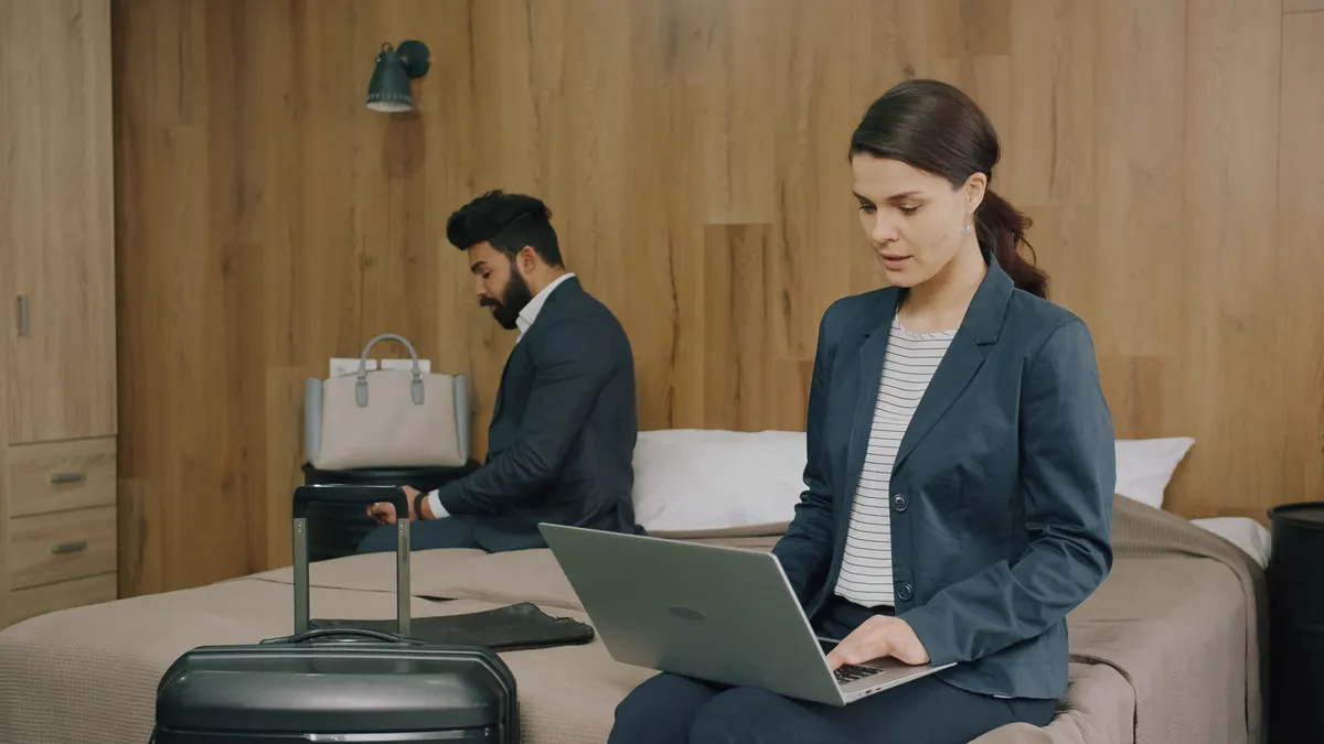 Two business travellers working in a hotel room