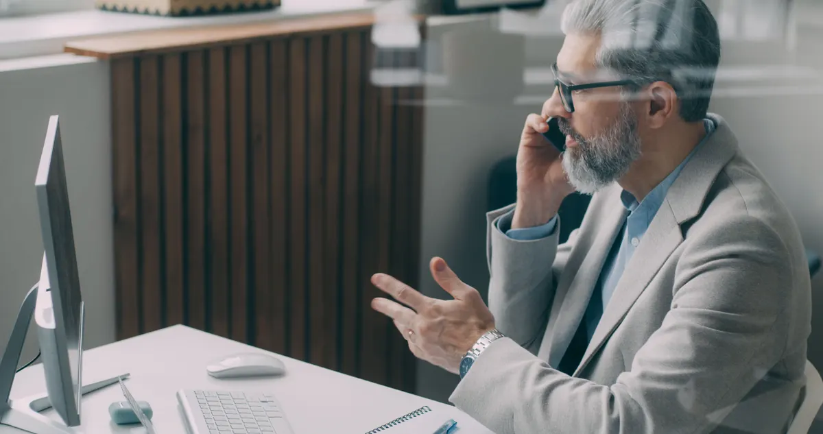 Office worker on the phone in a glass-walled office